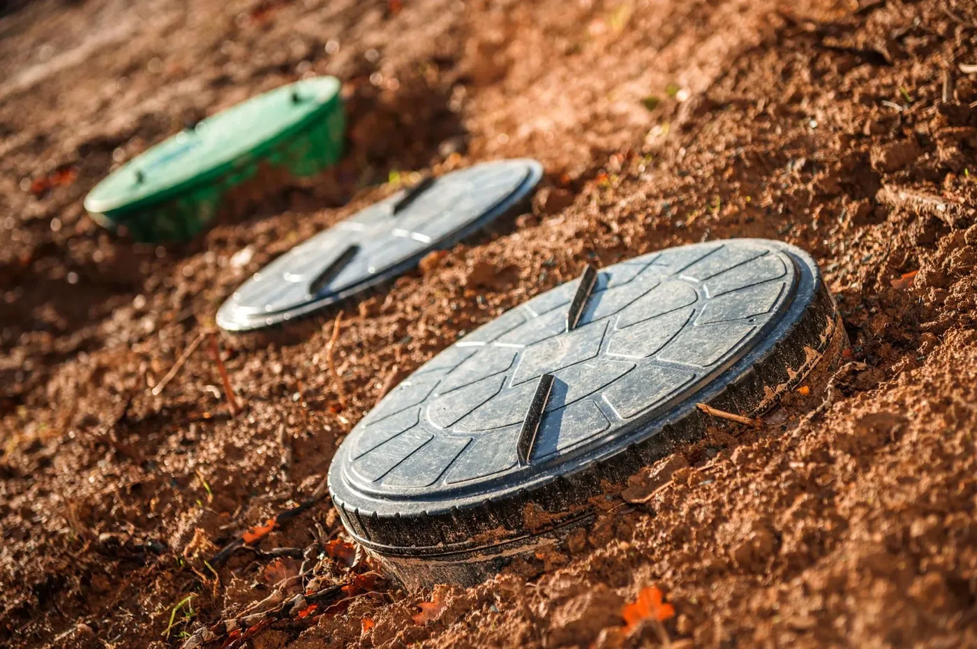 Properly installed septic tank lids set at ground level in warm afternoon light